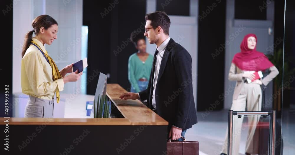 Young Businessman Arriving at Aiport. Flight Attendant Woman At Registration Deck Checking Client ID Information on PC. Worried People. Airport.