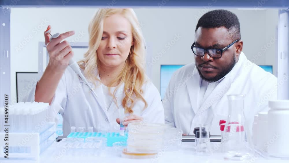 Professional team of scientists is working on a vaccine in a modern scientific research laboratory. Genetic engineer workplace. Futuristic technology and science concept. Professional team of scientists is working on a vaccine in a modern scientific research laboratory. Genetic engineer workplace. Futuristic technology and science concept.