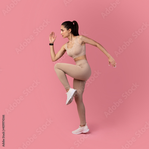 Young Woman Running And Exercising Isolated On Pink Background