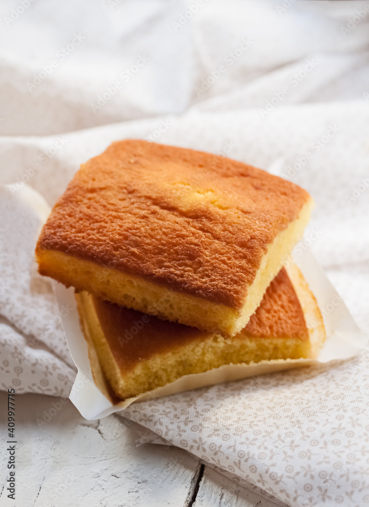 Yummy sweet baked Spanish sobao pasiego cakes served on white wooden table with napkin Yummy sweet baked Spanish sobao pasiego cakes served on white wooden table with napkin