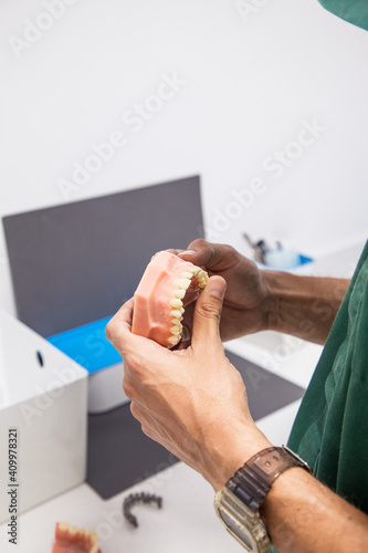 Cropped unrecognizable dentist holding dental cast in dentistry laboratory photo