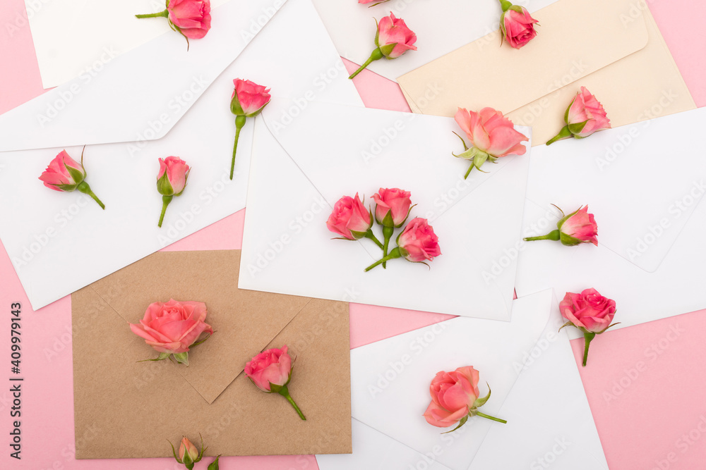 top view of small tea roses on envelopes and letters top view of small tea roses on envelopes and letters
