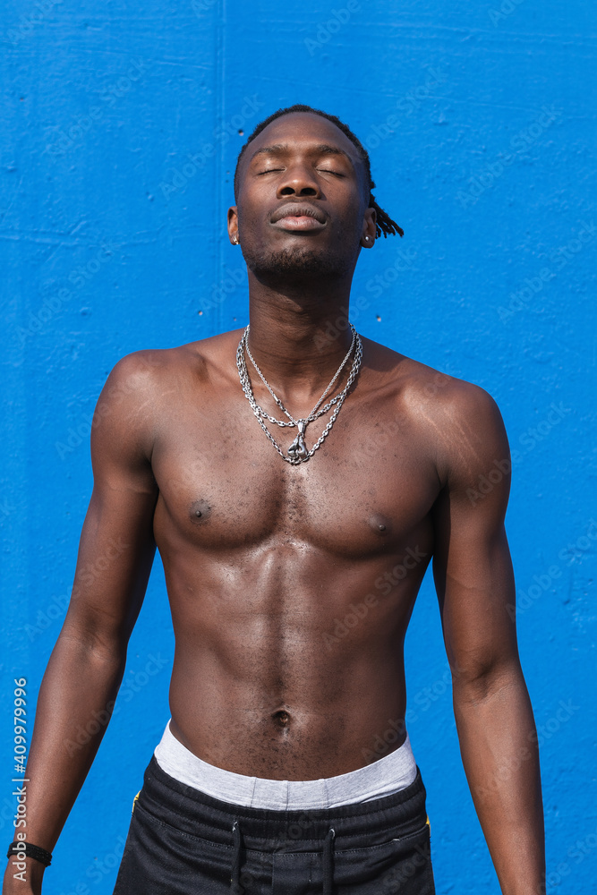 Confident shirtless young African American male with strong muscular ...