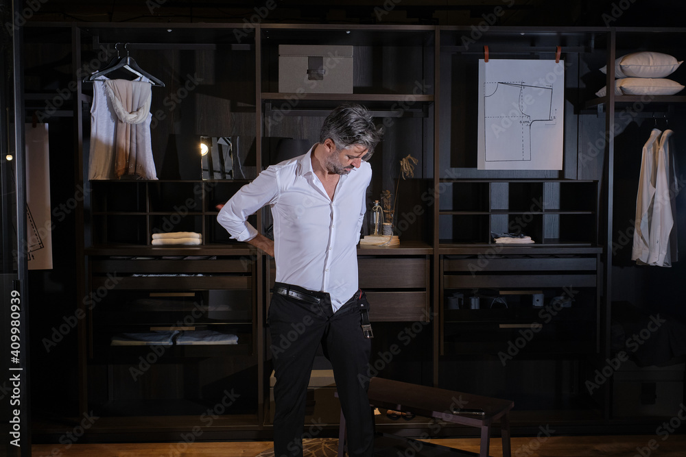 Stock photo of middle aged man dressing up in big dressing room. Stock photo of middle aged man dressing up in big dressing room.