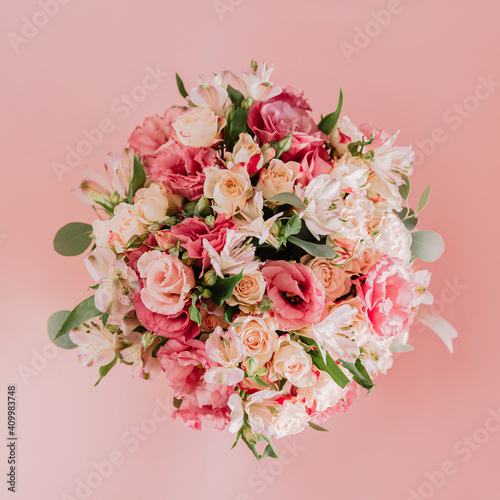 Bouquet with pink anemones and roses and eucalyptus branches in round pink box. On pink background. Present, spring time, happy women's day. Top view. © ekaeka