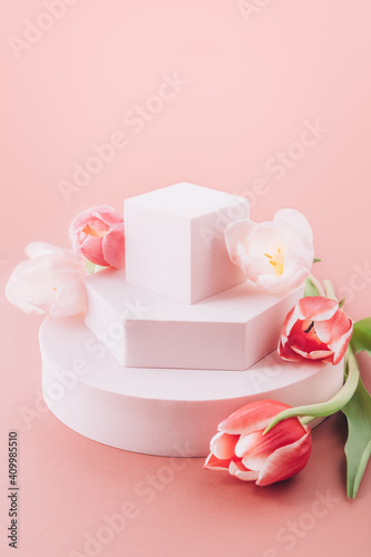 Solid Display Block for Shop Windows with tulips on pink background, empty podium for product presentation, geometric stand for cosmetics