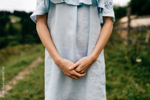 Сropped shot of elegant girl in blue romantic dress posing in the countryside © benevolente