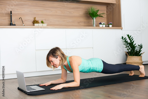 Woman doing a plank exercise while practicing online
