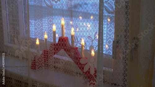 Slow motion of a car passes outside window with curtain and lamp candles
