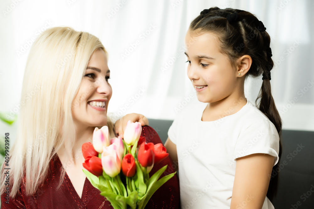 Woman and child with bouquet of flowers against home background. Spring family holiday concept. Women's day Woman and child with bouquet of flowers against home background. Spring family holiday concept. Women's day