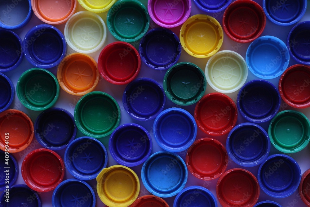 Background made of plastic colorsful bottle tops, caps. Dark background. Background made of plastic colorsful bottle tops, caps. Dark background.