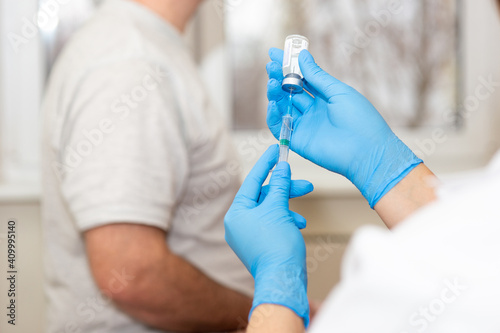 A doctor or nurse prepares to vaccinate a patient