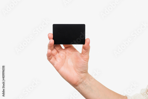 Business card in female hand, closeup isolated on white background. Close up of womans hand holding blank black card
