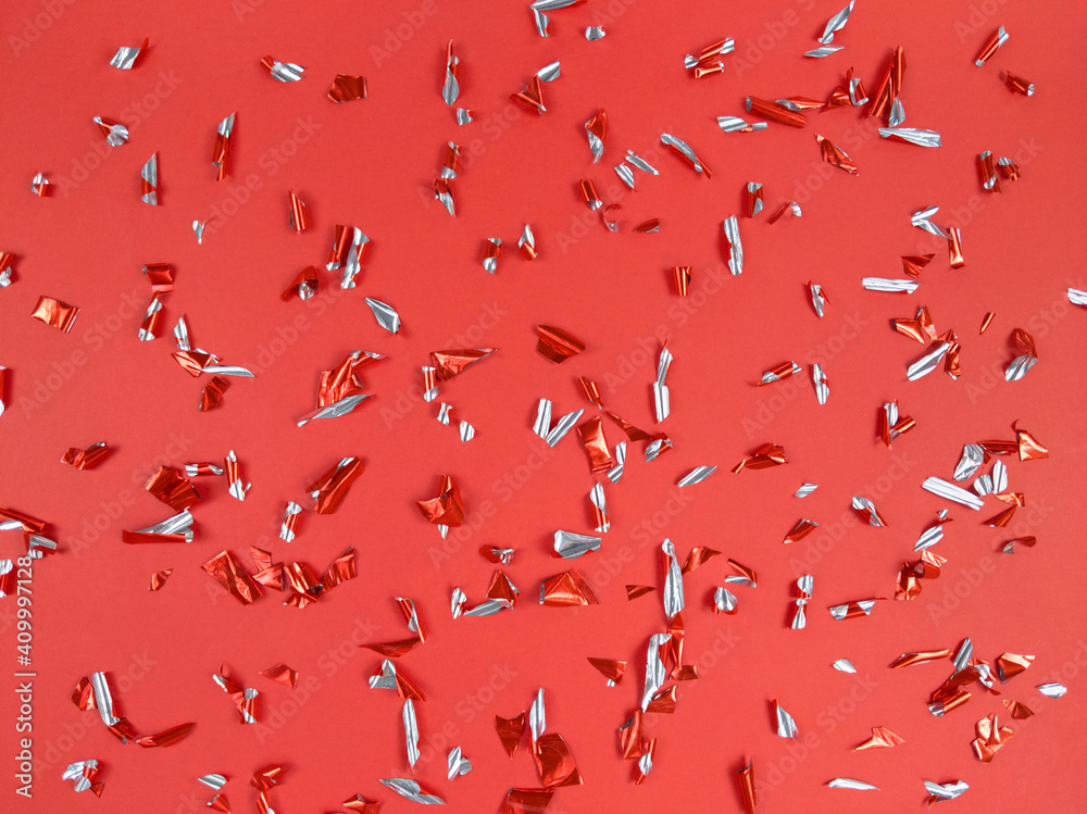 Confetti foil pieces on red background. Abstract festive backdrop. Confetti foil pieces on red background. Abstract festive backdrop.