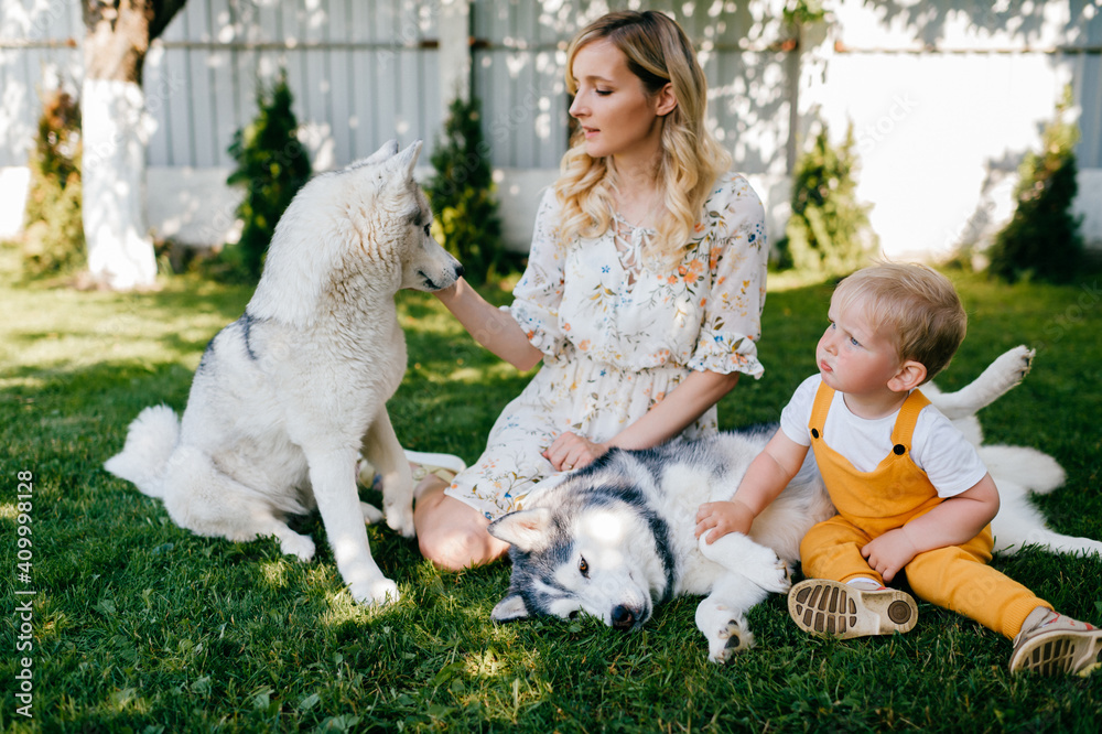Mother and son posing with a dog on the grass Mother and son posing with a dog on the grass