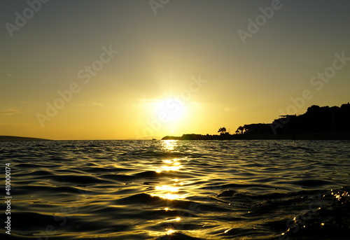 Wavy and shiny sea water surface at sunset