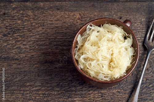 Fermented cabbage in a pot, top view with copy space
