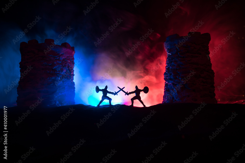 Obraz premium Medieval battle scene. Silhouettes of figures as separate objects, fight between warriors at night. Creative artwork decoration. Foggy background.