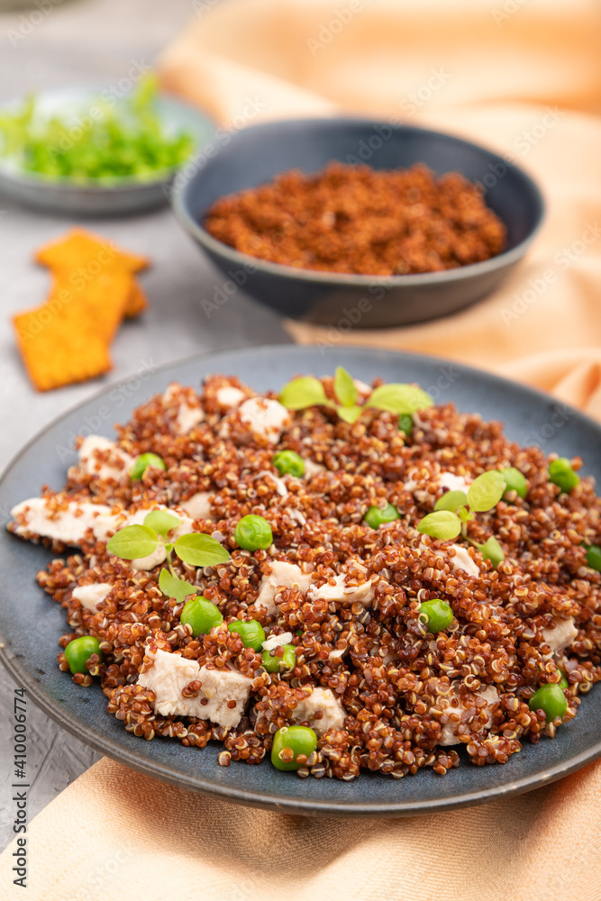 Quinoa porridge with green pea and chicken on ceramic plate on a gray concrete background. Side view, selective focus. Quinoa porridge with green pea and chicken on ceramic plate on a gray concrete background. Side view, selective focus.