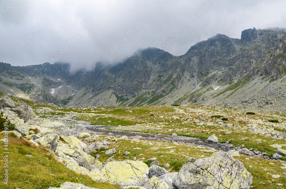 Fototapeta premium Beautiful sharp rocky peaks of mountain ranges under cloudy sky in the High Tatras, Slovakia
