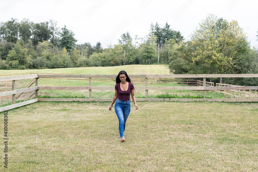 Happy woman walking in the grass of a ranch Happy woman walking in the grass of a ranch