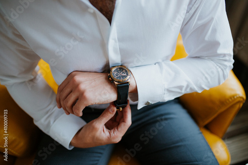 businessman checking time on his wrist watch, man putting clock on hand,groom getting ready in the morning before wedding ceremony