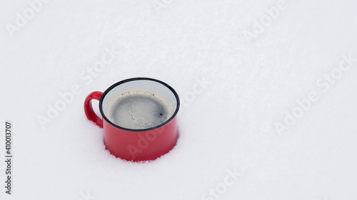 Red cup of coffee in a snow. Side view