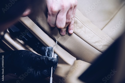 Foto Car renovation studio worker renovating car leather seat