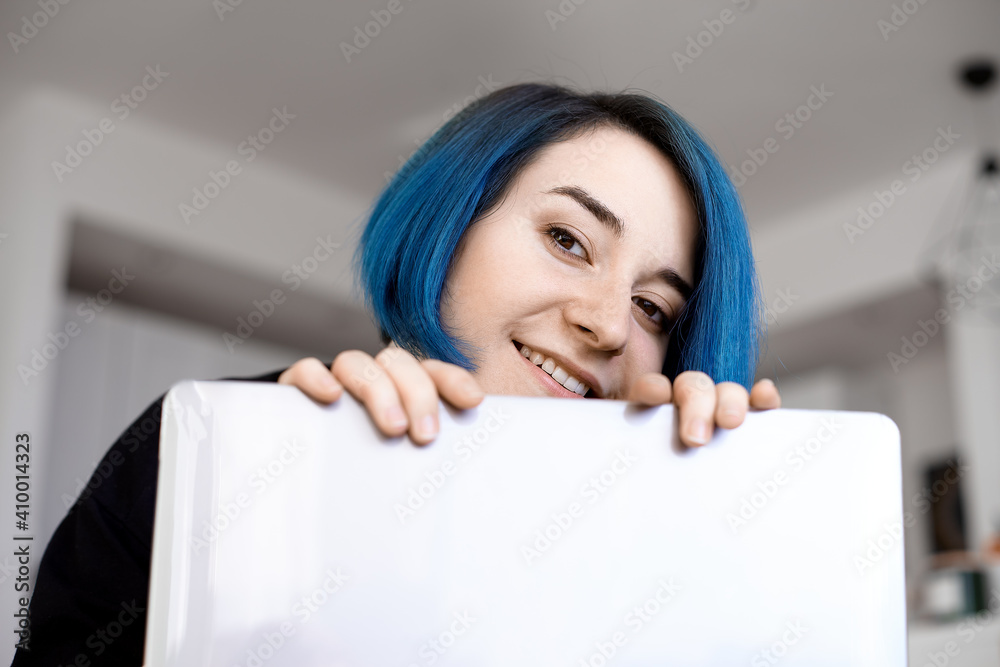 Smiling women with blue hair working long hours from her home office. Student girl working at home. Work or study from home, freelance, business. Smiling women with blue hair working long hours from her home office. Student girl working at home. Work or study from home, freelance, business.