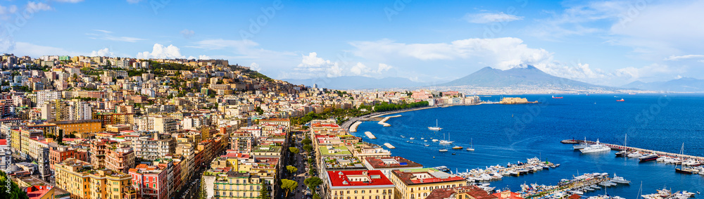 Naples city and port with Mount Vesuvius on the horizon seen from the hills of Posilipo. Seaside landscape of the city harbor and gulf on the Tyrrhenian Sea