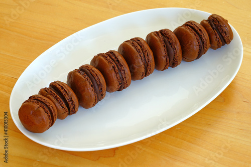 Homemade Chocolate cocoa macaron cookies on a white platter