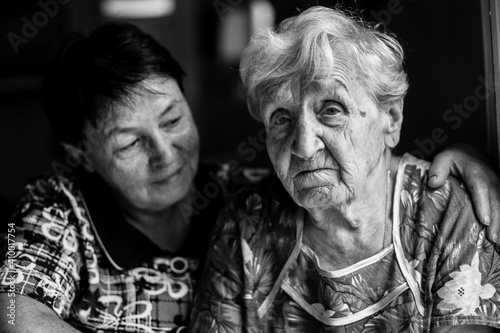 Portrait of a old woman with adult daughter. Black and white photo.