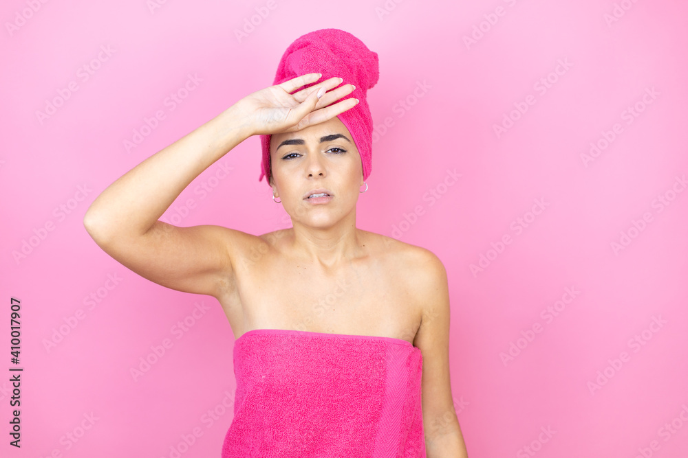 Young beautiful woman wearing shower towel after bath standing over isolated pink background Touching forehead for illness and fever, flu and cold, virus sick Young beautiful woman wearing shower towel after bath standing over isolated pink background Touching forehead for illness and fever, flu and cold, virus sick