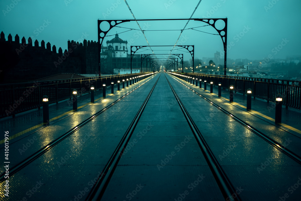 View of the Dom Luis I Iron Bridge in cloudy weather at night, in Porto, Portugal.