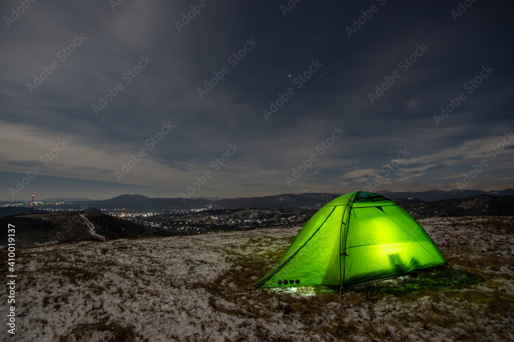 Tent in winter on top of the mountain at night