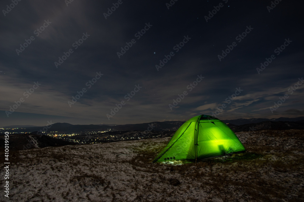 Tent in winter on top of the mountain at night