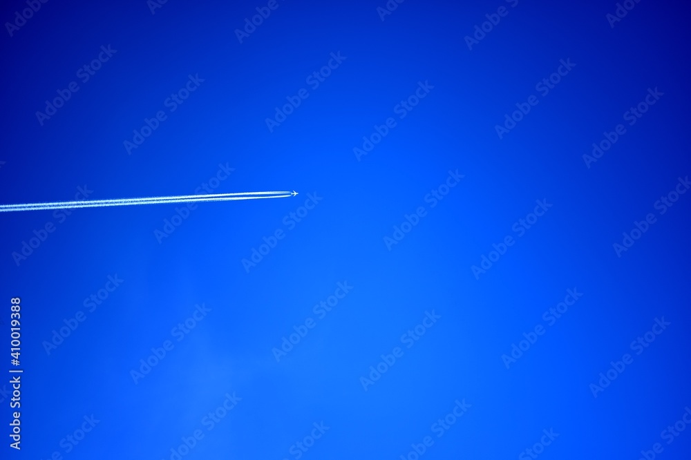 Low angle shot of an airplane flying in the blue sky Low angle shot of an airplane flying in the blue sky