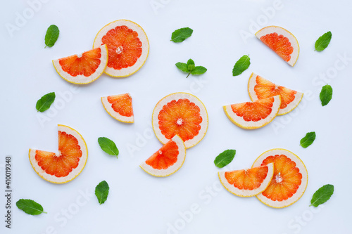 Fototapeta Naklejka Na Ścianę i Meble -  High vitamin C. Juicy grapefruit slices with mint leaves on white