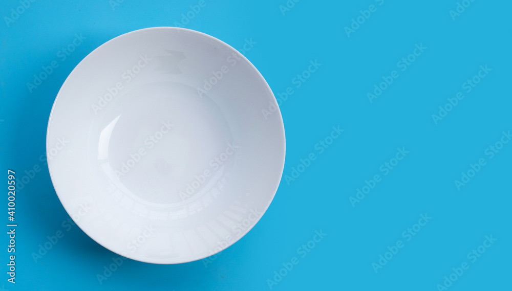 Empty white bowl on blue background.