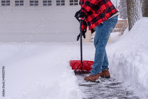 Canvas Print Man shoveling heavy snow in the driveway