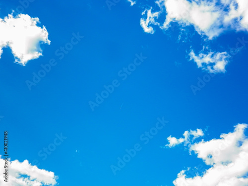 White soft clouds against a bright blue summer sky photo
