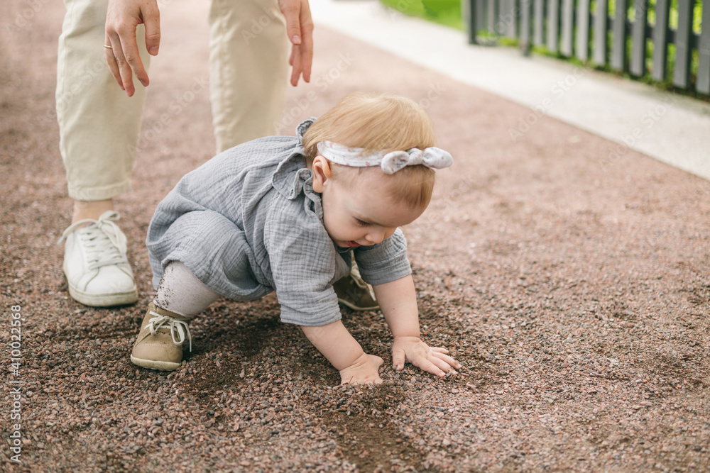 A one-year-old girl got dirty in the ground while walking. Walking with your child, letting touch the dirt, explore the world around you A one-year-old girl got dirty in the ground while walking. Walking with your child, letting touch the dirt, explore the world around you
