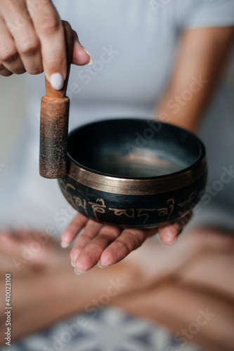Close up image of woman's hands holding Tibetan Singing Bowl Outdoors.Sound therapy, recreation, meditation, healthy lifestyle. Young woman practicing yoga. Yoga and healthy lifestyle concept