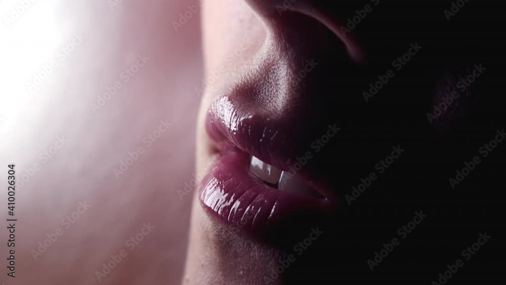 Cropped shot of young sexy woman bite her lips with desire. Seductive sensual facial expression. Slow motion, macro 4k.