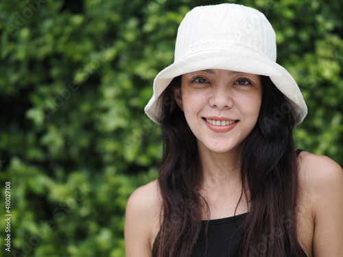 portrait of young asian woman in black dress and white hat