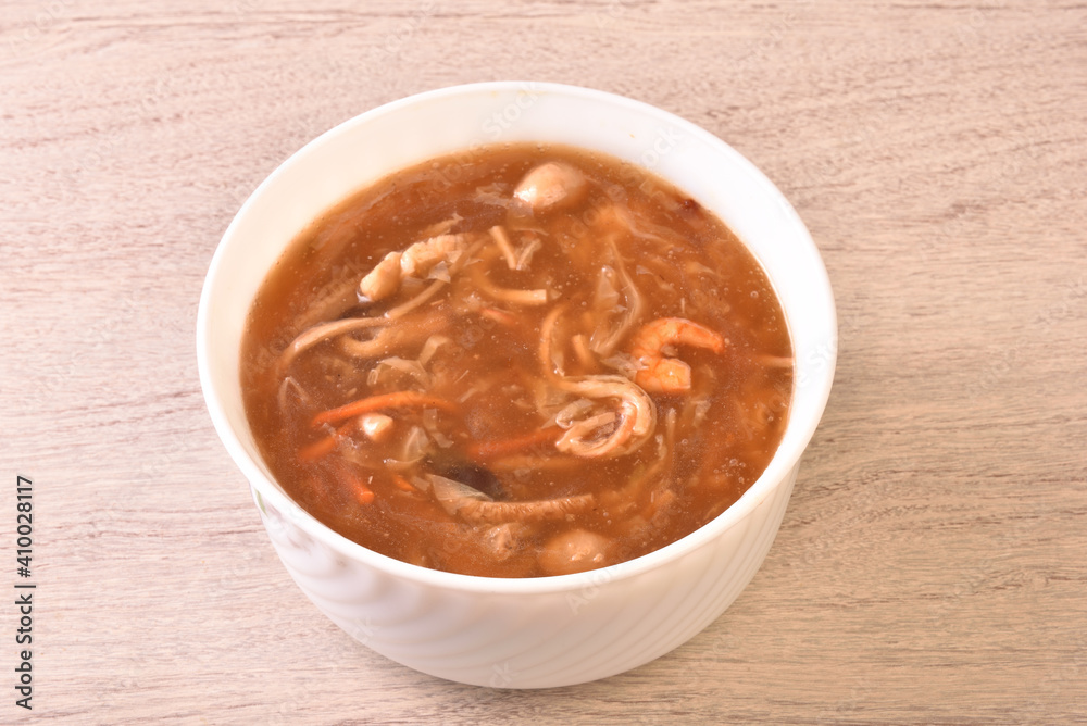 Assorted seafood with scallops soup in white bowl Assorted seafood with scallops soup in white bowl