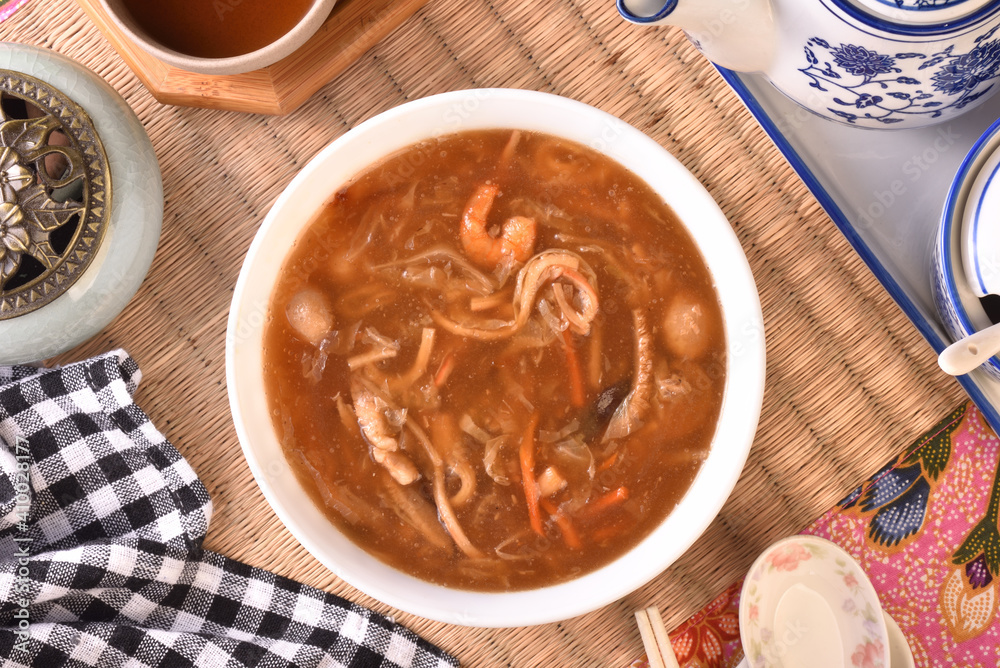 Assorted seafood with scallops soup in white bowl