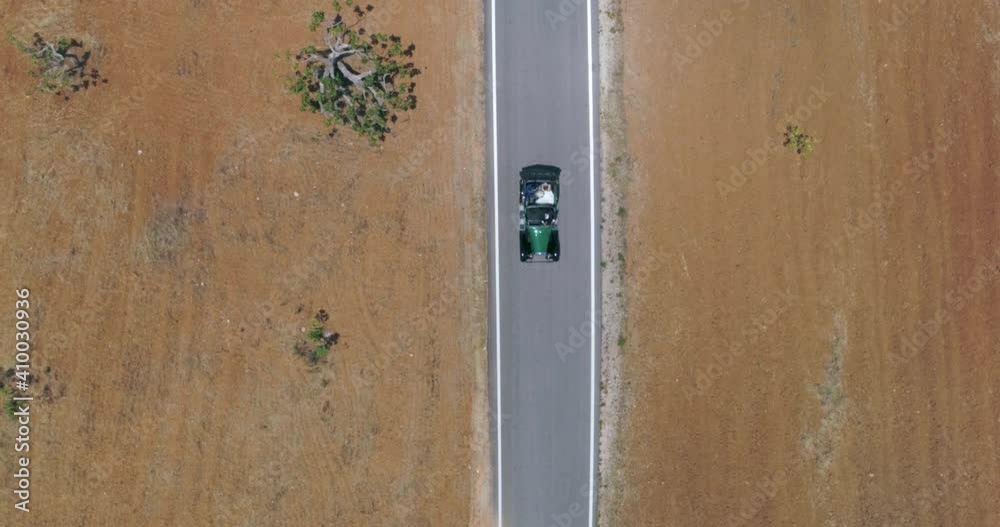 Aerial Top Down View of a classic car on a countryside road. Algarve, Portugal. Aerial Top Down View of a classic car on a countryside road. Algarve, Portugal.