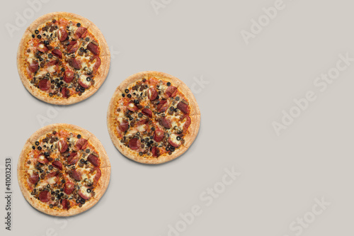 The pizzas are delicious and the ingredients are sausage, bacon and mozzarella on a brown background. can be made of backgrounds, flyers and other forms of advertising, photo