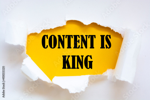 CONTENT IS KING appearing behind torn paper. Business